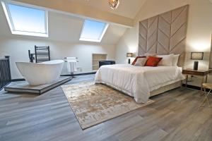 a bedroom with a large bed and a bath tub at Black Pearl Stays in Saltburn-by-the-Sea