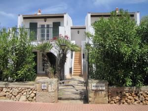 a white house with a staircase in front of it at Apartamentos Marivent in Cala en Blanes