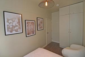 a bedroom with a bed and a chair and pictures on the wall at Black Pearl Stays in Saltburn-by-the-Sea