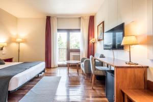 フォルミガルにあるSnö Hotel Formigalのベッドとデスクが備わるホテルルームです。
