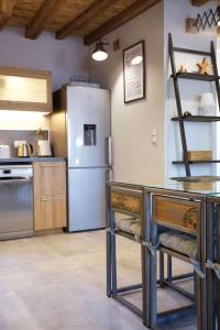 uma cozinha com um frigorífico e uma mesa com cadeiras em Château de Laforest - Les Hébergements em Thizy-les-Bourgs