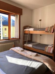 Mountain House في Rigolato: غرفة بسريرين بطابقين ونافذة