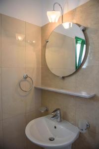 a bathroom with a sink and a mirror at Yperia Hotel in Aegiali