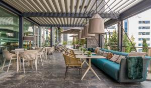 a patio with a blue couch and tables and chairs at Ilunion Atrium in Madrid