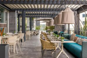 un restaurante con sofá azul, mesas y sillas en Ilunion Atrium en Madrid