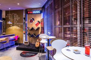 a restaurant with two tables and a guitar on the wall at Hotel ibis Porto Gaia in Vila Nova de Gaia