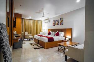 um quarto de hotel com uma cama, uma secretária e cadeiras em Saltstayz Executive Studio Apartment em Gurgaon