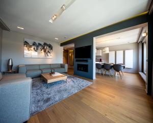 a living room with a blue couch and a table at Core Luxembourg City- Luxury Brands Street in Luxembourg