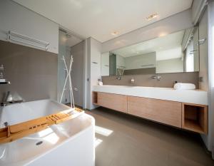 a bathroom with a tub and a large mirror at Core Luxembourg City- Luxury Brands Street in Luxembourg