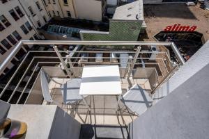 d'un balcon avec une table et des chaises blanches. dans l'établissement Core Luxembourg City- Luxury Brands Street, à Luxembourg