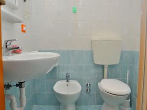 ein Bad mit einem WC und einem Waschbecken in der Unterkunft Loving apartment with garden view - Beahost in Bibione