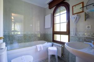 a white bathroom with a tub and a sink at Posada El Trasmerano in Argoños