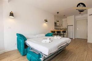 a bedroom with a large bed with blue chairs at Apartamento El SolAire centro Torremolinos in Torremolinos