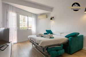 a room with a bed with a couch and a tv at Apartamento El SolAire centro Torremolinos in Torremolinos