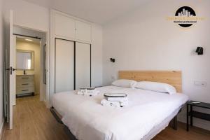 a bedroom with a large white bed with two dishes on it at Apartamento El SolAire centro Torremolinos in Torremolinos