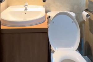 a bathroom with a white toilet and a sink at RedLiving Apartemen Transpark Cibubur - Ens Room in Depok