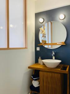 a bathroom with a sink and a mirror at Rêve Salé Appartement Vue Mer 2 à 4 pers in Dieppe