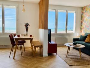 a living room with a table and a living room with the ocean at Rêve Salé Appartement Vue Mer 2 à 4 pers in Dieppe +6 photos