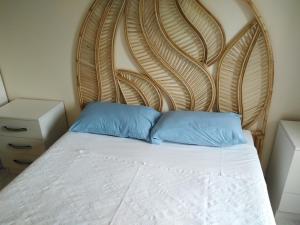 uma cama com cabeceira em madeira e 2 almofadas azuis em Villa Çalış em Fethiye