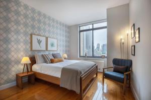 une chambre avec un lit et une chaise bleue dans l'établissement Modern Bright Times Sq 1BR w Indoor pool NYC-8, à New York