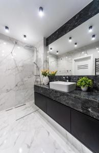 baño con lavabo y espejo grande en Новая квартира с авторским ремонтом в ЖК Seven Днепровская набережная, en Kiev