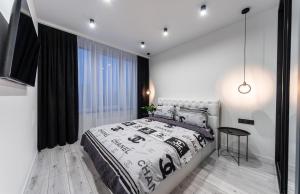 Un dormitorio con una cama grande y una ventana en Новая квартира с авторским ремонтом в ЖК Seven Днепровская набережная, en Kiev