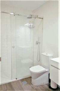 uma casa de banho branca com um chuveiro e um WC. em Vale Do Mar House em Espinho