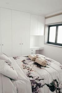 um quarto branco com uma cama com almofadas em Vale Do Mar House em Espinho