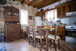 a kitchen with wooden cabinets and a table with fruit on it at Villa Mavrianos Sea View in Kithnos