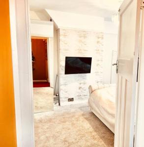 1 dormitorio con 1 cama y TV en la pared en Liverpool - Cosy Jazzy Beach Home! en Waterloo