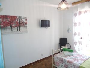 een slaapkamer met een bed en een tv aan de muur bij Casa Vacanza LiHele - Locazione Turistica in Castelsardo