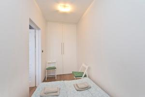 a white room with a bed and two chairs at Kawalerka Studio Stare Domki in Gdańsk