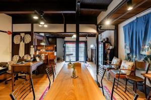 een woonkamer met een lange houten tafel en stoelen bij Tsukito in Kyoto