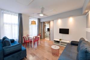 a living room with a couch and a table with chairs at Kawalerka Studio Stare Domki in Gdańsk