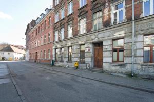 an empty street in front of an old building at Kawalerka Studio Stare Domki in Gdańsk
