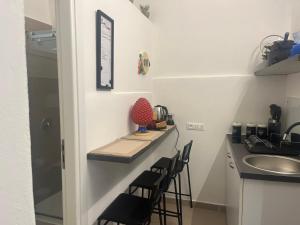 a small kitchen with a counter and stools at La casetta mape in Palermo