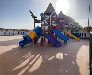 a playground with a slide at a park at Apartement haut standing avec piscine à la Marina Saidia in Saïdia