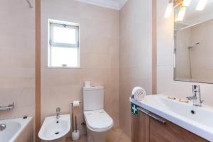 a bathroom with a white toilet and a sink at Apartamento Férias Lagos in Lagos +10 photos