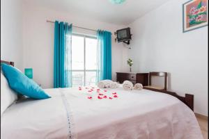 a bedroom with a bed with red roses on it at Apartamento Férias Lagos in Lagos