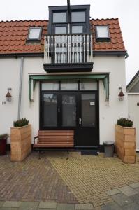 a building with a bench and a balcony at D'rommels Goed Slapen in Den Helder