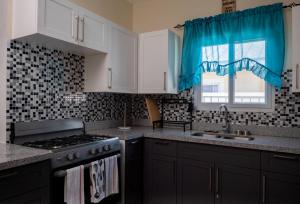 una cucina con fornelli, lavello e finestra di Hamilton @ Oceanpointe a serene 2bed 2 bath Villa a Lucea