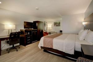 a hotel room with a bed and a desk and a computer at Quality Inn & Suites in Lincoln