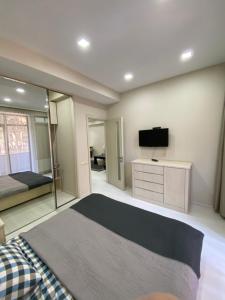 a bedroom with a bed and a flat screen tv at Apartment Vake in Tbilisi City