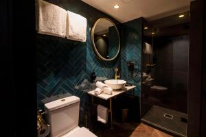 a bathroom with a toilet and a sink and a mirror at Hotel Haarhuis in Arnhem