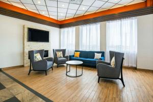 Sala de espera con sofá, sillas y mesa en Comfort Inn & Suites, en Barrie