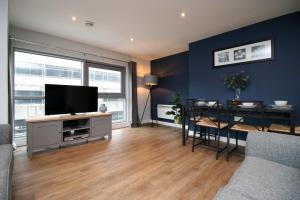 sala de estar con TV de pantalla plana y mesa en Violet's Corner Luxury Apartment by StayStaycations en Swindon