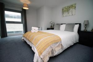 Un dormitorio con una cama grande con dos animales de peluche. en Violet's Corner Luxury Apartment by StayStaycations en Swindon