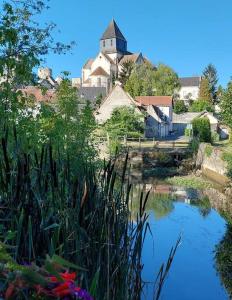 un pequeño estanque con una iglesia al fondo en Le Guet du Garde - in the center of medieval town en Châtillon-sur-Indre