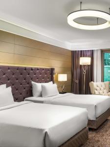 a hotel room with two beds and a large headboard at Radisson Blu Hotel, Istanbul Sisli in Istanbul