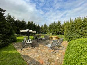 a patio with a table and chairs and an umbrella at Kétpáva Vendégház in Igal